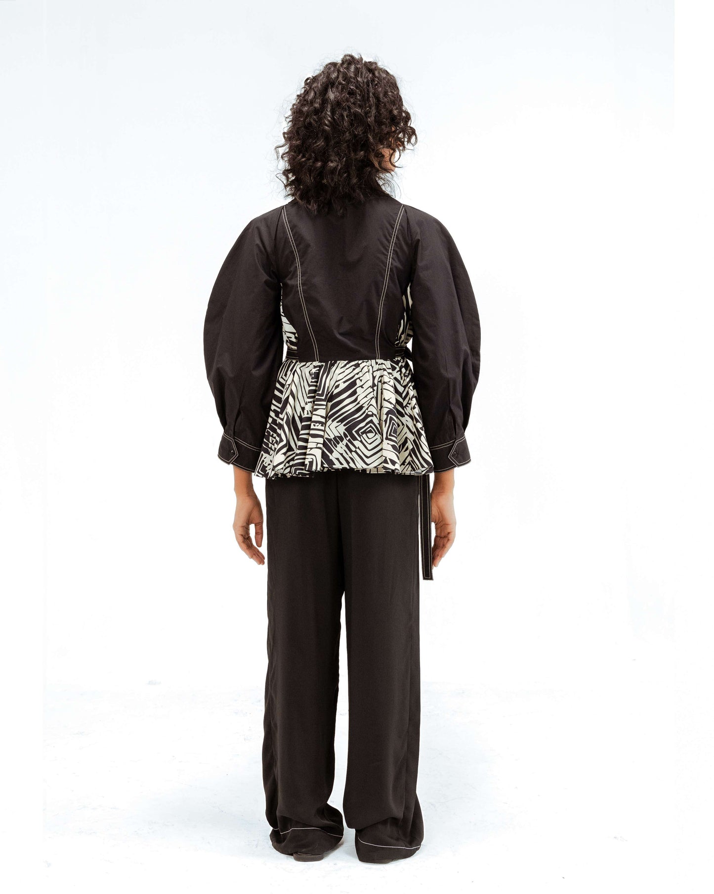Leh Studios Fable top from the Rhythm of time collection, a black sustainable fashion piece featuring voluminous sleeves, intricate white stitching, and a pleated black and white abstract pattern. Made with organic cotton and showcasing artisanal craftsmanship, perfect for eco-conscious womens apparel.