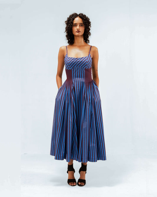 Leh Studios Meva Dress from the Rhythm of time collection, a stunning blue and maroon striped midi dress with spaghetti straps, a fitted bodice, and a full pleated skirt with pockets, showcasing sustainable fashion and eco-friendly design for womens apparel crafted from organic cotton.