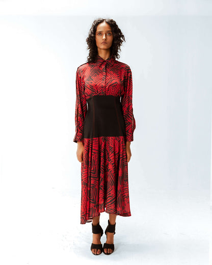 Woman wearing a red and black patterned dress on a white background from Leh Studios.