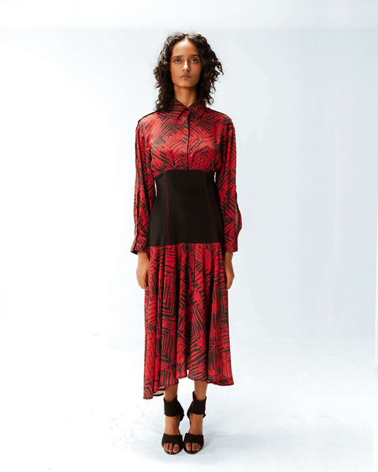 Woman wearing a red and black patterned dress on a white background from Leh Studios.