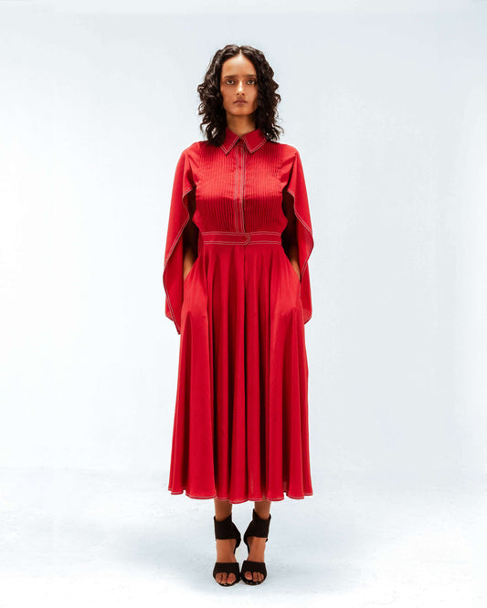 Woman wearing a red dress with a cape on a white background from Leh Studios.