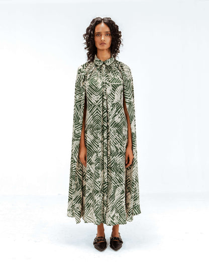 Woman wearing a green and white patterned dress on a white background from Leh Studios.