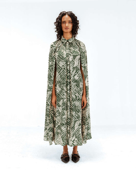 Woman wearing a green and white patterned dress on a white background from Leh Studios.