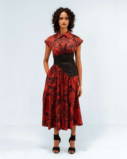 Leh Studios presents the Florix Print Basque Tiered Dress, a luxury upcycled fashion piece from the Rhythm of time collection. This handcrafted apparel for womens apparel, featuring bold red and black patterns with a structured black basque waist and cap sleeves, reflects artisanal craftsmanship and sustainable Indian fashion.