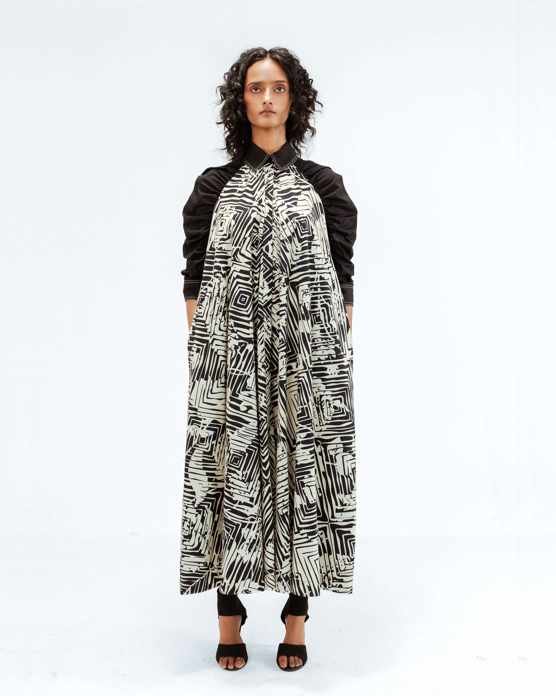 Experience contemporary design with the Leh Studios Florix Print Fable Dress from the Rhythm of time collection. This elegant black and white patterned womens apparel, made with a collared neckline and long sleeves, embraces ethical fashion principles and eco-friendly design.