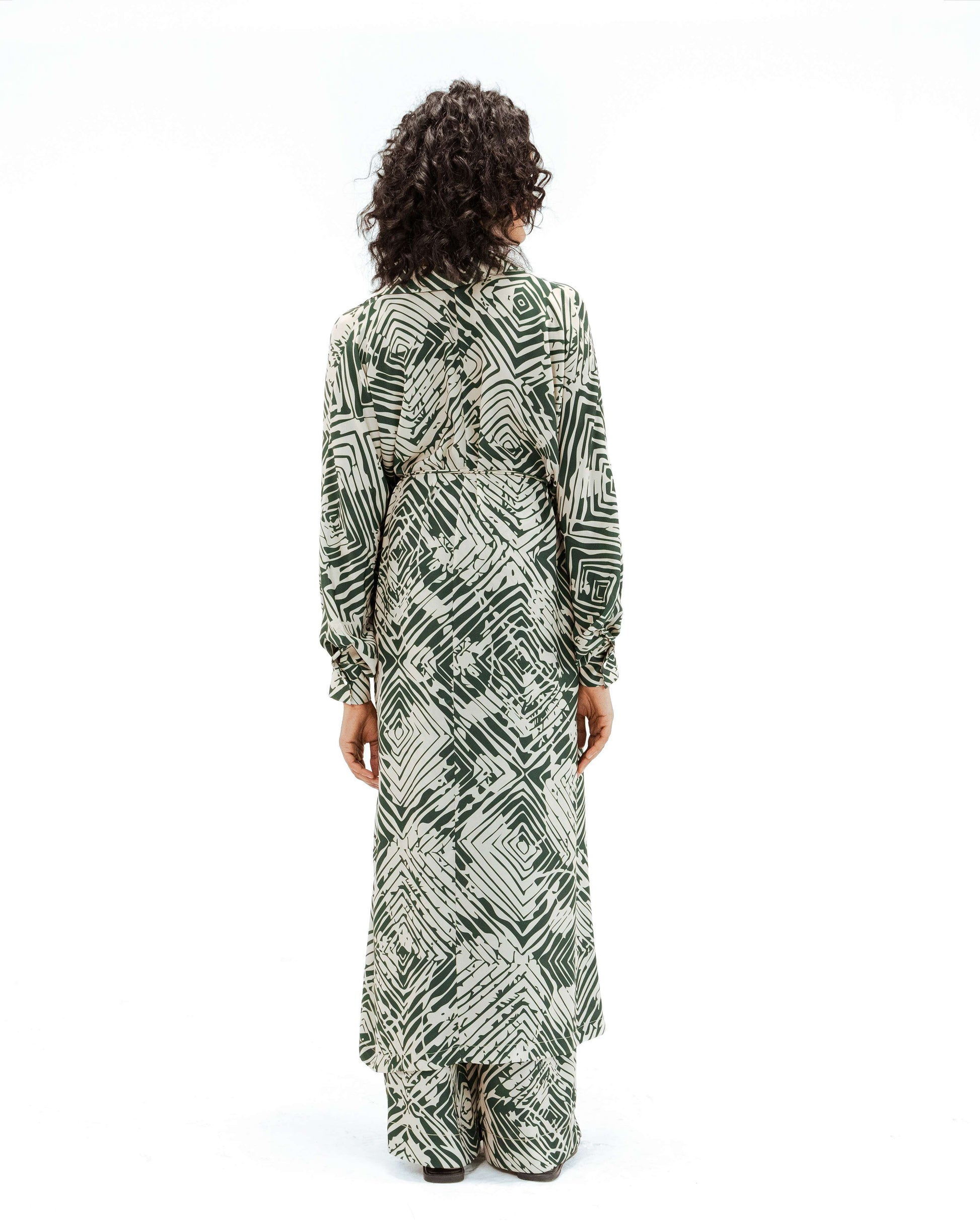 Back view of the Leh Studios Florix Print Crepe Cape Dress, part of the Rhythm of Time collection. This chic womens apparel is crafted with sustainable fashion principles, featuring a vibrant green geometric Florix print on flowing crepe fabric, showcasing Leh clothing's dedication to responsible creativity and designer dresses.