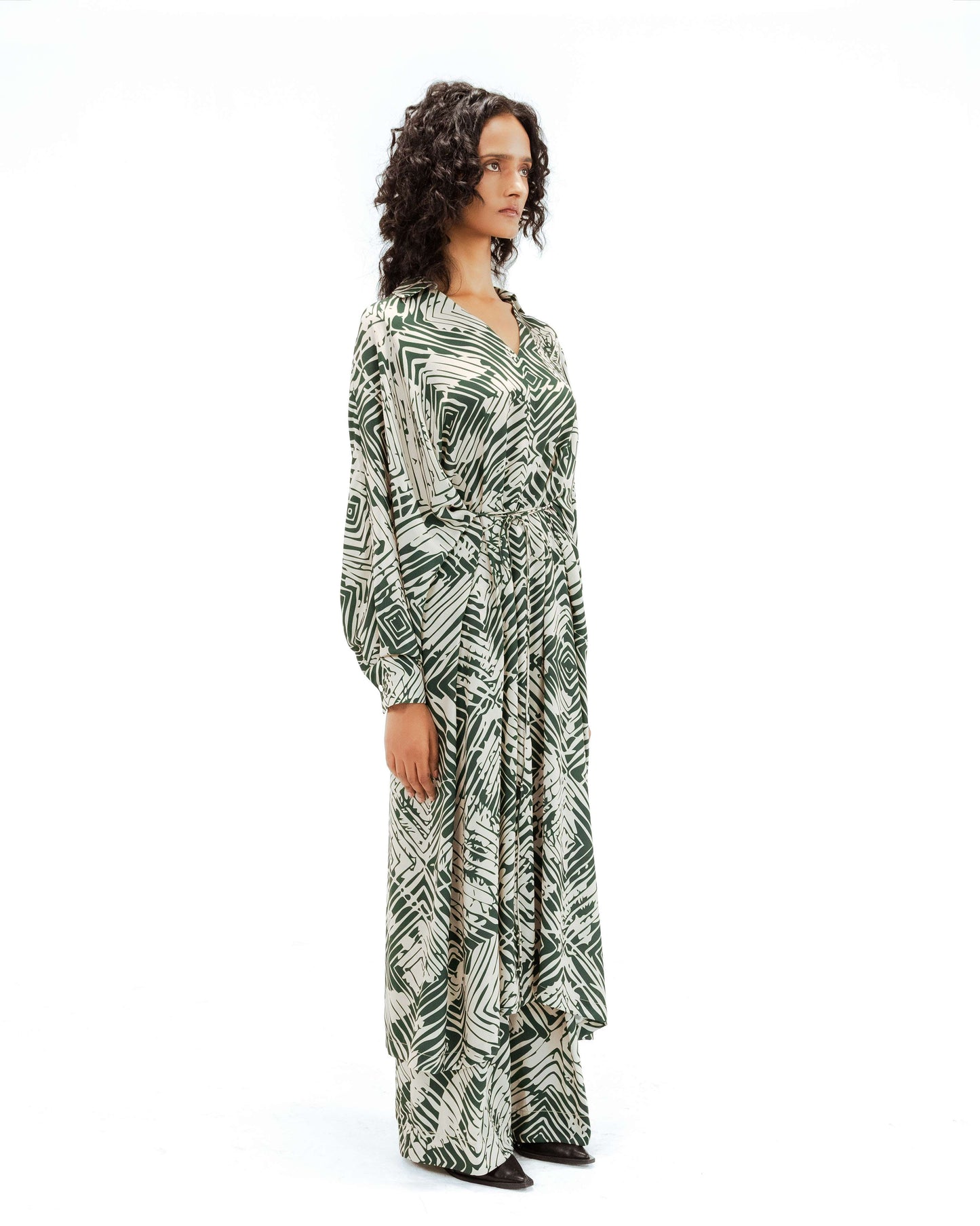 Woman wearing a long, patterned dress on a white background from Leh Studios.