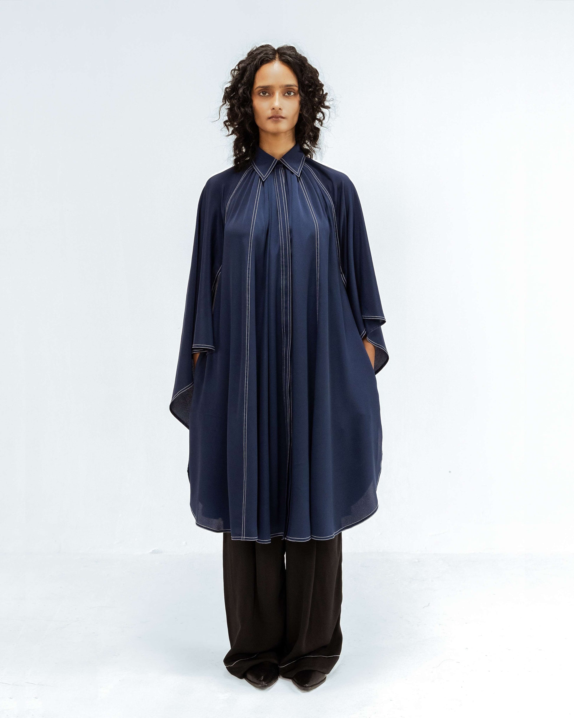 The Leh Studios Selene Crepe Set, part of the Rhythm of time collection, is worn by a model. This elegant designer wear features a navy blue crepe tunic and black trousers, both accented with unique white stitching, highlighting eco-friendly design and ethical fashion from Leh clothing.