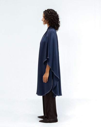 A model in profile showcases the Leh Studios Selene Crepe Set from the Rhythm of time collection, featuring a dark blue sustainable tunic top with white contrast stitching and matching black trousers. This elegant womens apparel highlights eco-friendly design and contemporary Indian fashion.