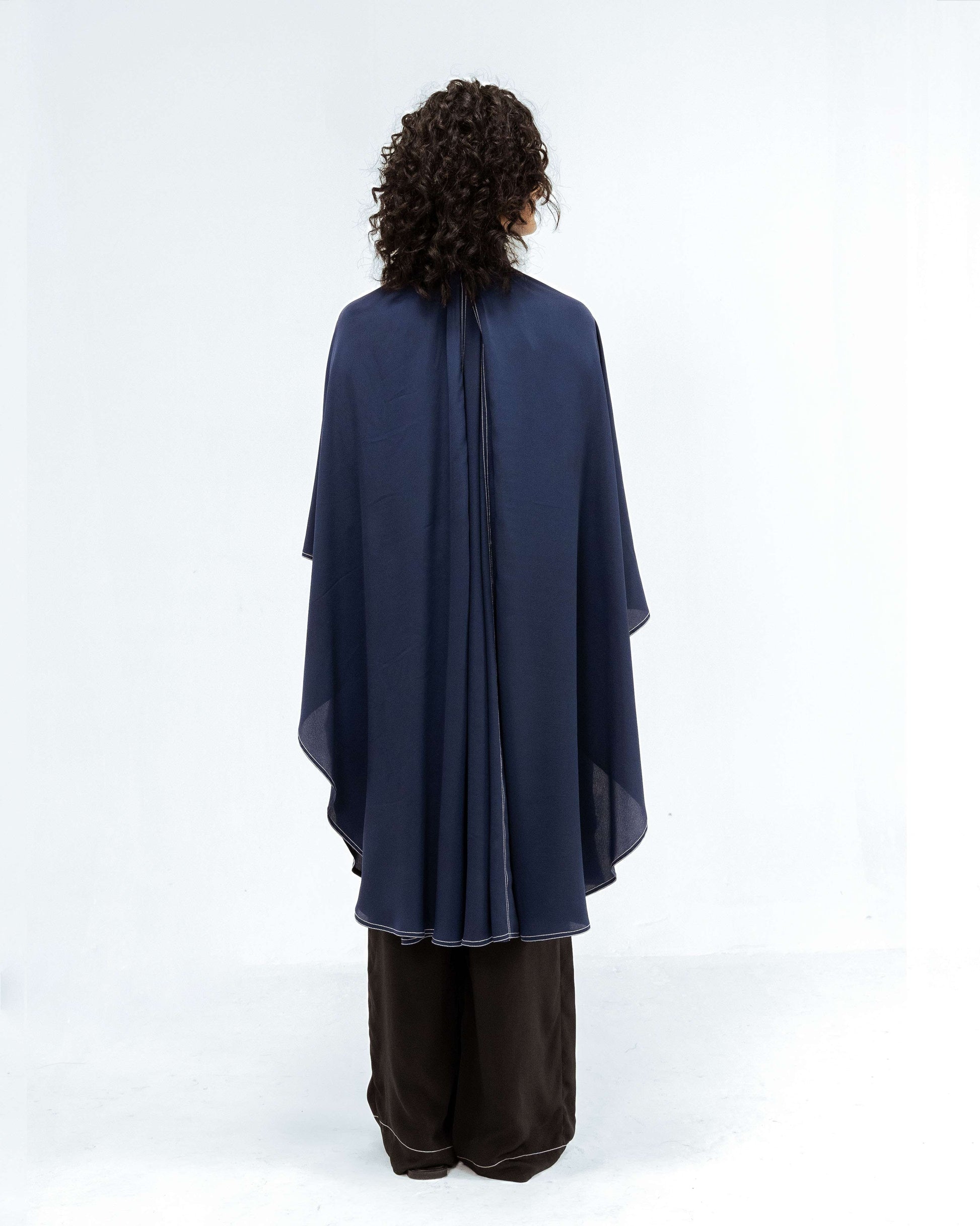 Model from behind wearing the Leh Studios Selene Crepe Set from the Rhythm of time collection, featuring a flowing navy blue crepe top with unique white stitch details and dark wide-leg trousers. This designer wear exemplifies sustainable fashion and artisanal craftsmanship for modern womens apparel.