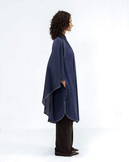 The Leh Studios Selene Crepe Set, part of the Rhythm of time collection, is modelled by a woman. This upcycled clothing ensemble includes a dark blue crepe top with intricate white stitching details and a relaxed, eco-friendly design, paired with wide-leg black trousers, highlighting ethical fashion for womens apparel.